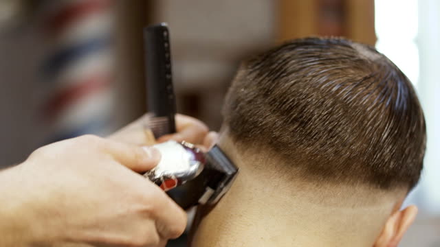 Barber-cuts-hair-with-electric-razor