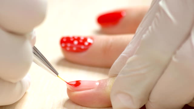 Close-up-manicurist-painting-on-nails.