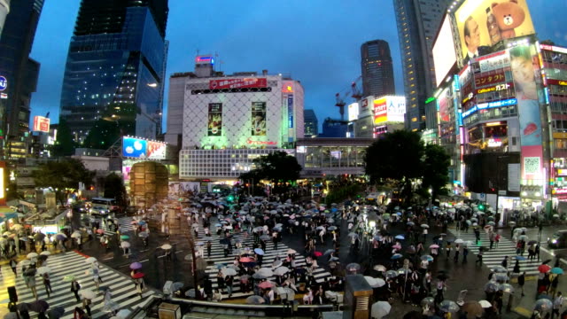 4K-Time-lapse-video-of-people-with-umbrellas-cross-the-famous-diagonal-intersection-in-Shibuya,-Tokyo,-Japan