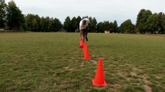 Entrenador-de-fútbol-recoge-los-conos-del-campo