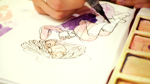 artist-drawing-a-sketch-with-the-watercolors-paints