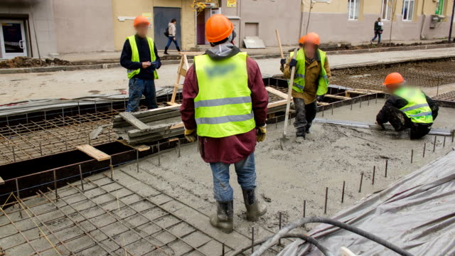 Betonarbeiten-für-den-Straßenbau-Wartung-mit-vielen-Arbeitern-und-Mixer-timelapse