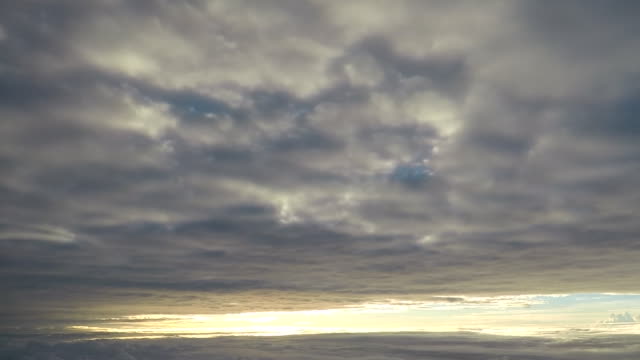 Avión-volando-entre-dos-capas-de-nubes-al-amanecer