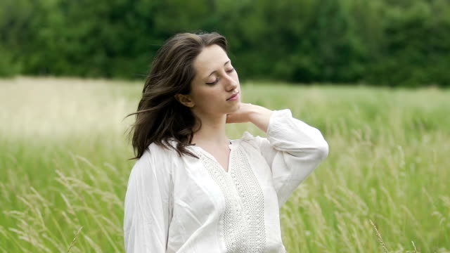 Woman-with-eyes-closed-standing-in-field-feeling-wind-and-oneness-with-nature