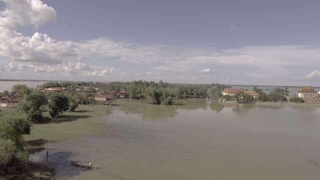 Luftbild-Drohne-geschossen:-fliegen-in-Richtung-ein-verschlafenes-Dorf,-umgeben-von-Hochwasser