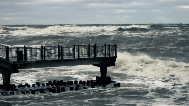 High-wave-breaking-on-the-rocks-of-the-coastline.-Stormy-weather-on-sea-with-big-wave-breaking-on-breakwater.-Slow-Motion.