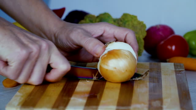 Man-is-cutting-vegetables-in-the-kitchen,-slicing-tomato-in-slow-motion