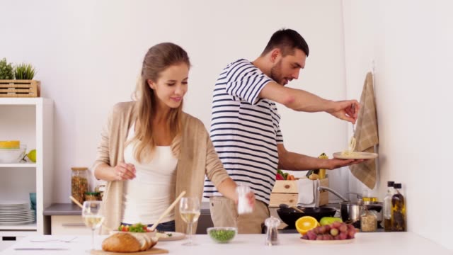 glückliches-Paar-Kochen-und-servieren-von-Speisen-zu-Hause