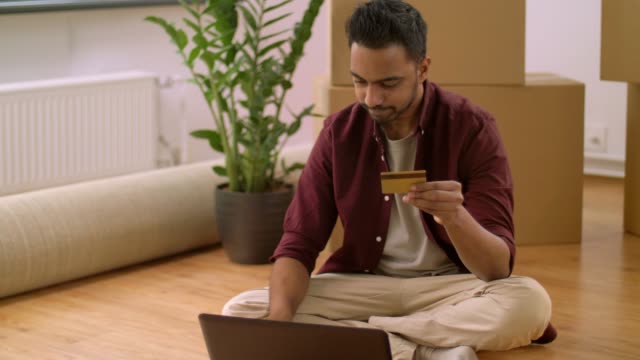 hombre-con-el-ordenador-portátil,-compras-en-línea-en-el-nuevo-hogar