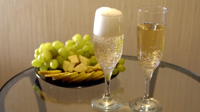 Champagner-Gläser-und-einen-Teller-mit-Obst-auf-dem-Tisch