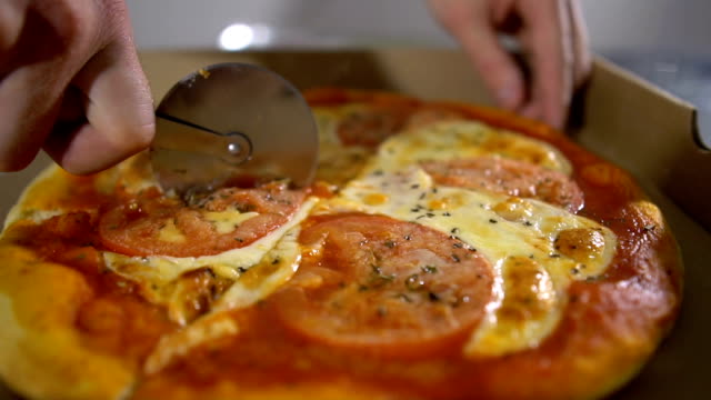 Man-chef-cuts-the-mouth-watering-hot-and-delicious-pizza-close-up