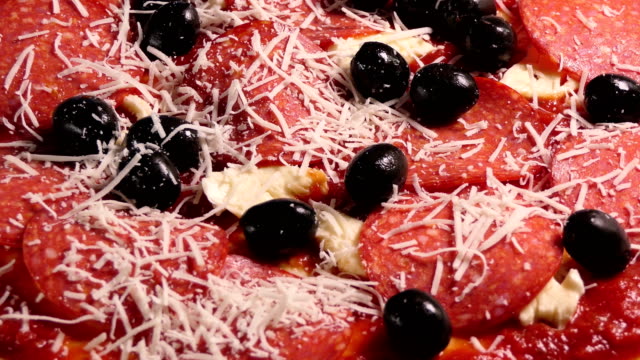 Preparing-pizza-toping.-Laying-parmesan-cheese-and-shredded-bsil-leaves-on-pizza-topping.