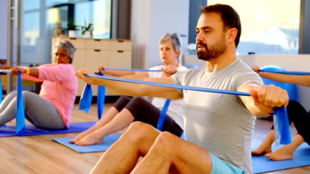 Entrenador-de-asistencia-a-senior-femenino-en-la-realización-de-yoga-4k