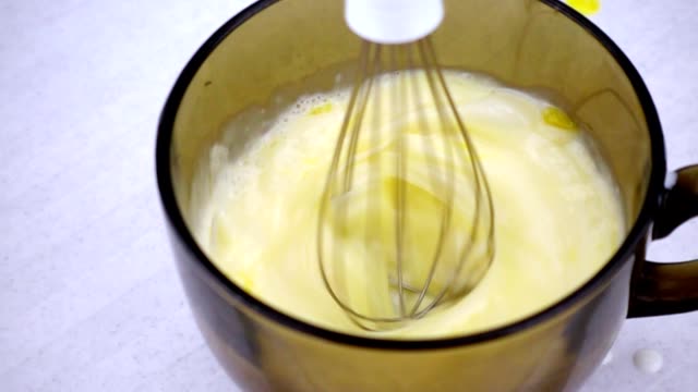 Electric-mixer-whisk-the-eggs-in-a-bowl-with-milk.-Working-mixer-in-slow-motion.