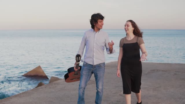 Beautiful-musician-couple-walk-walk-along-the-pier-by-the-sea