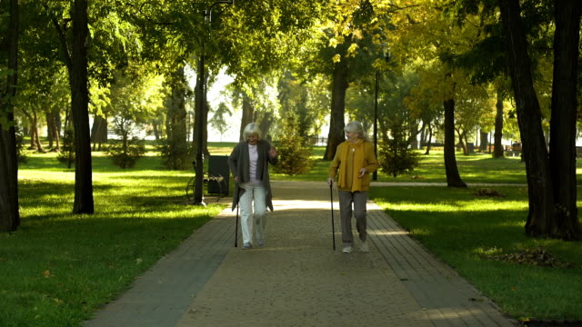Two-happy-senior-women-walking-in-park,-nursing-home-for-elderly-people,-leisure