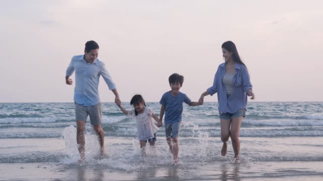 SLOW-MOTION,-familia-asiática-corriendo-con-feliz-emoción-en-la-playa-juntos.-Concepto-de-familia,-vacaciones-y-viajes.