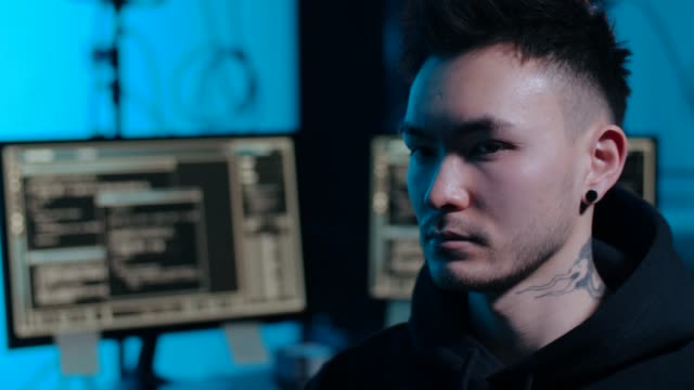 hacker-asiático-en-habitación-oscura-con-computadoras-por-la-noche