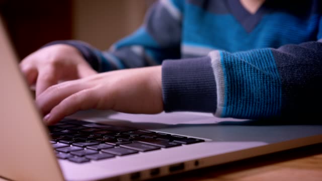 Sesión-de-perfil-de-primer-plano-de-manos-lindo-niño-pequeño-escribiendo-en-el-ordenador-portátil.