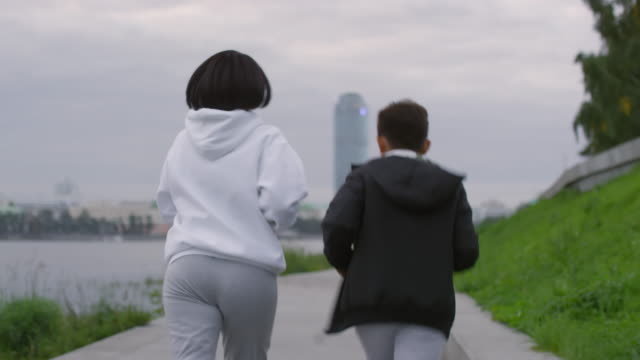Mother-and-Son-Running-Along-City-Riverside