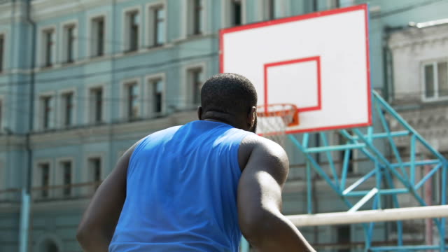 Persona-afro-americana-motivada-lanzando-la-bola-en-la-canasta,-deportes-hobby