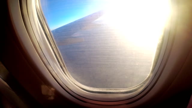 Ver-desde-la-ventana-de-un-avión-de-pasajeros-durante-la-puesta-de-sol-en-un-paisaje-y-un-horizonte