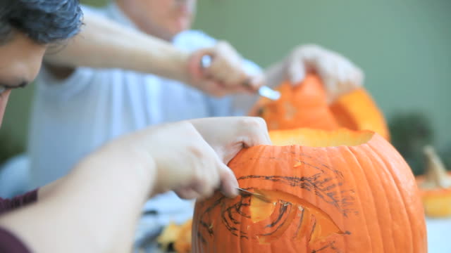 Two-men-carving-Halloween-pumpkins