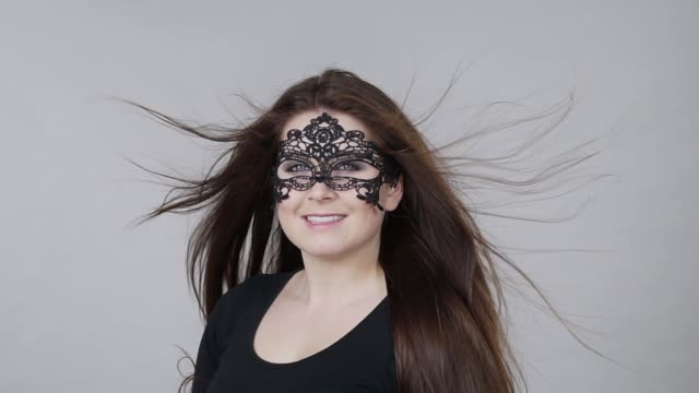 Mujer-con-máscara-de-carnaval-cabello-largo-soplar
