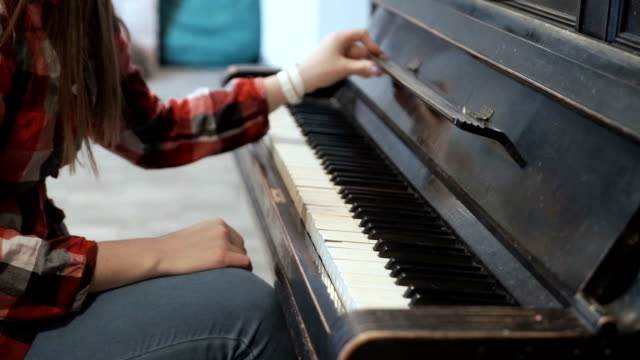 Weibchen-berührt-sanft-Notenständer-aus-Klavier