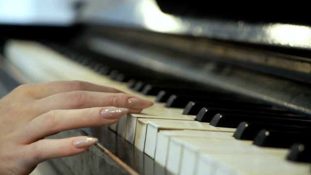 Woman-gently-touches-piano-keys