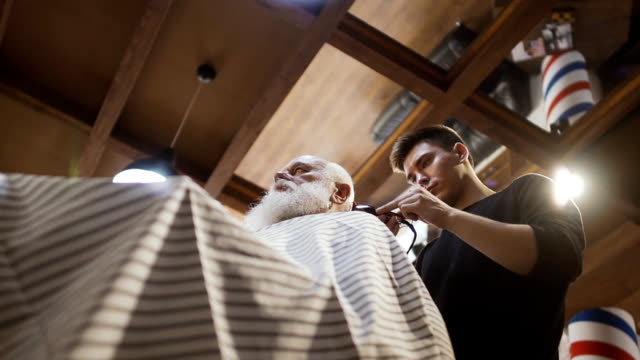 Hairdresser-makes-stylish-haircut-for-senior-man