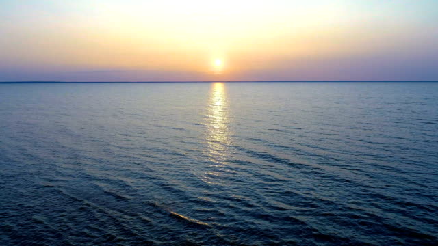 Der-Flug-über-das-Wasser-auf-den-malerischen-Sonnenaufgang-Hintergrund.-Drohne-Schuss