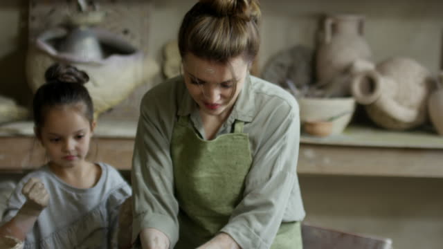Mujer-artesana-docente-niño-en-la-clase-de-cerámica