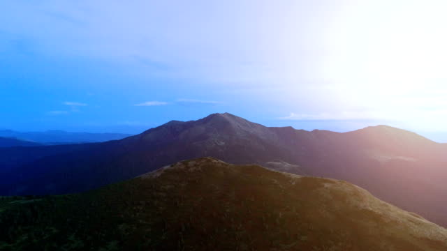 Der-Flug-über-die-malerischen-Berge-im-Sonnenuntergang-Hintergrund