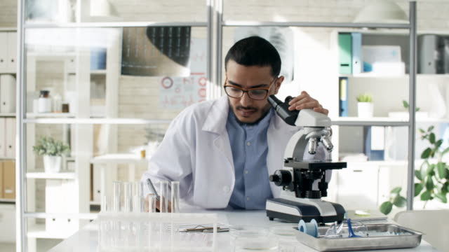 Konzentrierte-sich-schwarze-Wissenschaftler-mit-Mikroskop