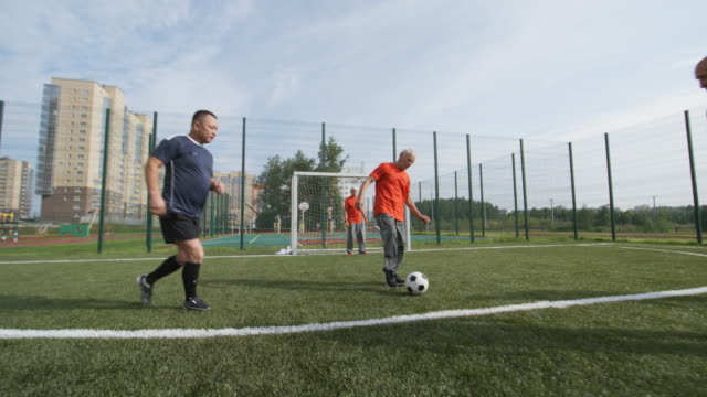 Jugadores-de-fútbol-mayores-jugando-al-aire-libre