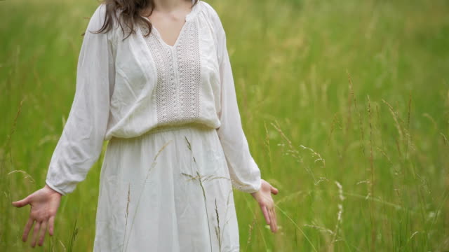 Einfach-gekleidete-Frau-Gefühl-Einheit-mit-der-Natur-stehen-im-Weizenfeld,-Hände