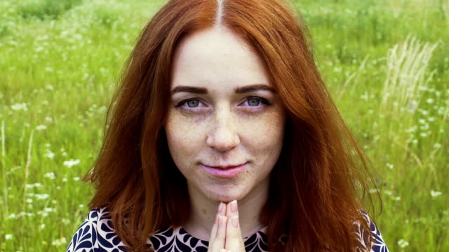 Praying-red-haired-woman-outdoors,-female-with-freckled-face-reads-God's-prayer