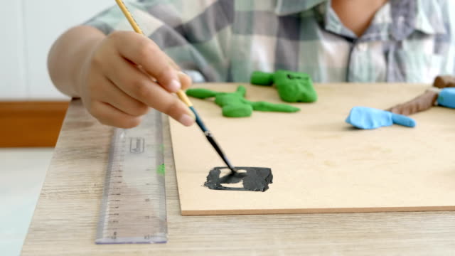Manos-del-niño-jugando-colores-arcilla-y-pintura-sobre-tabla.-Desarrollo-de-las-habilidades-motoras-finas-de-los-dedos-y-creatividad,-educación