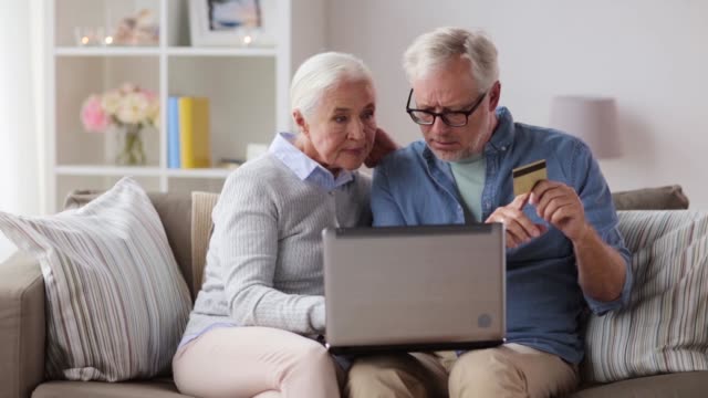 feliz-pareja-senior-con-laptop-y-tarjeta-de-crédito