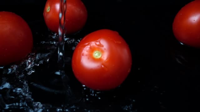 La-corriente-de-agua-fluye-en-tomates.-Cámara-lenta.