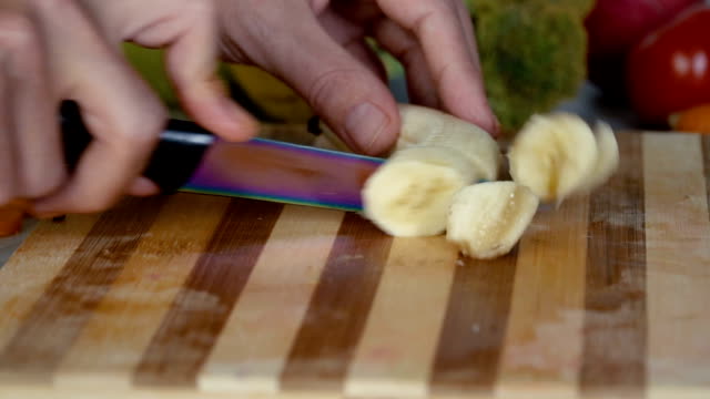 Der-Mensch-ist-schneiden-Banane-auf-Schneidebrett,-Filmmaterial-hautnah