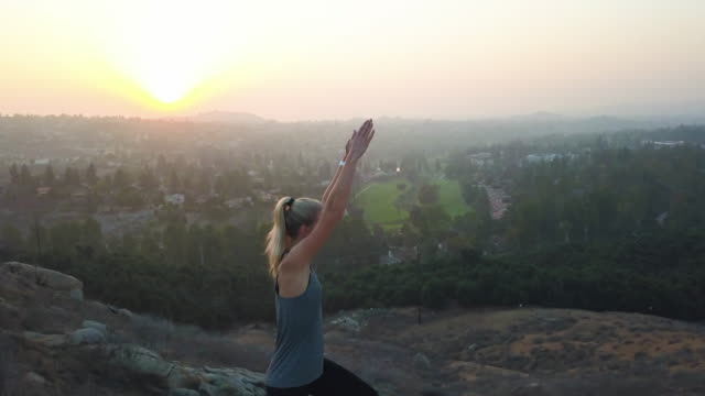 Strong-beautiful-woman-yoga-fitness-in-nature-sunset-aerial
