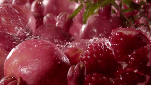 Pomegranate-falling-in-juice-with-splash-between-pomegranate.-Slow-motion