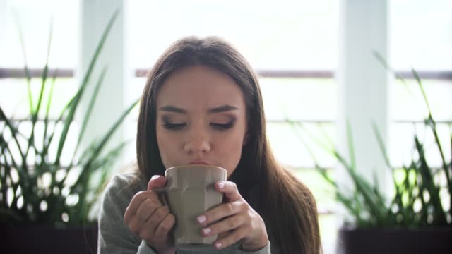 Müde-Frau-trinkt-Kaffee-trinken-im-Innenbereich