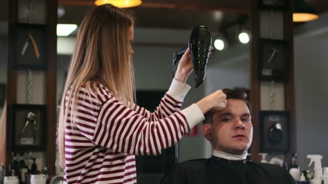 Barber-drying-male-hair-in-hairdressing-salon.-Close-up-hairdresser-blowing-man-hair-with-dryer-in-barbershop.-Male-hairstylish-doing-hairdo-in-beauty-studio