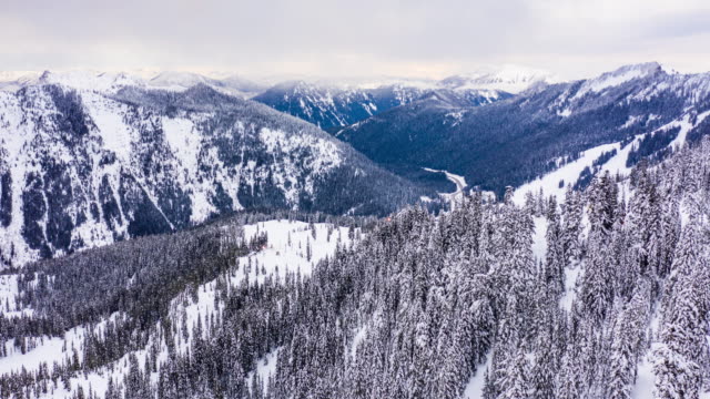Stevens-Pass-Winter-Scene-Snowing-Timelapse-Aerial-Flying-Towards-Ski-Resort-Mountain