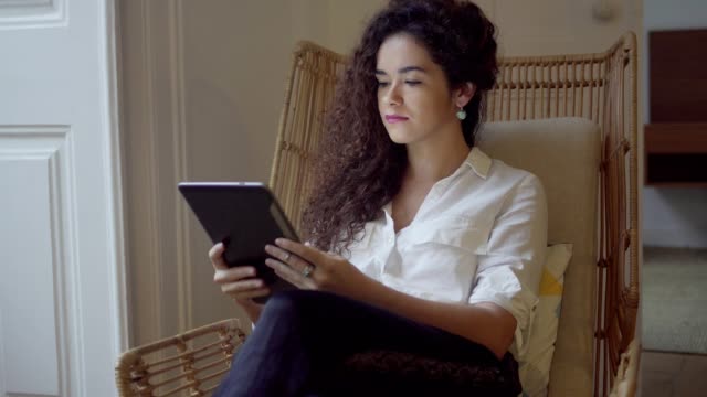 Schöne-fokussierte-junge-Frau,-die-mit-digital-Tablette