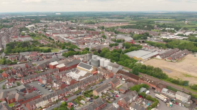Aerial-footage-overlooking-the-British-town-of-Castleford-near-Wakefield-in-West-Yorkshire,-showing-rows-of-houses-and-fields-in-the-background,-taken-on-a-sunny-bright-summers-day.