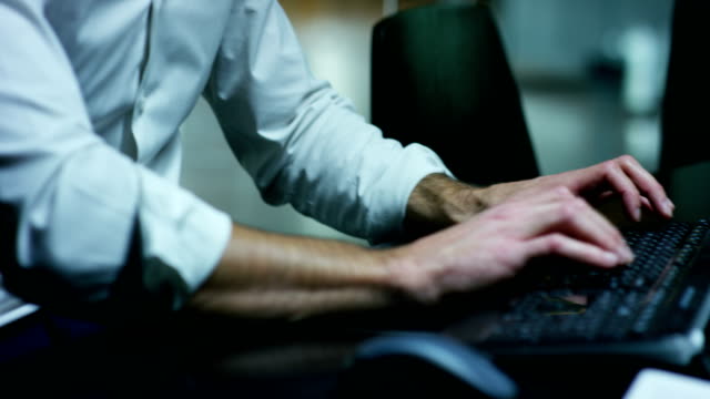 Manos-masculinas-escribiendo-/-trabajando-en-el-teclado-del-ordenador-portátil-en-la-oficina-(Macro-De-cerca)